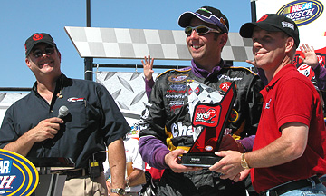 Scott hamilton gives Greg the trophy.